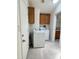 Practical laundry room features tiled flooring, a washer, a dryer and cabinetry at 8840 E Sunland Ave # 142, Mesa, AZ 85208