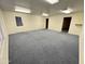 Spacious living room with blue carpet, neutral walls, and multiple entrances at 8840 E Sunland Ave # 142, Mesa, AZ 85208