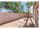 A nice, simple backyard features mature trees and partial concrete flooring at 8884 E Arizona Park Pl, Scottsdale, AZ 85260