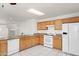 Functional kitchen featuring white appliances, oak cabinets, and granite countertops, and an open layout at 8884 E Arizona Park Pl, Scottsdale, AZ 85260