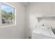 A well-lit laundry room with a washing machine and a large window for natural light at 8884 E Arizona Park Pl, Scottsdale, AZ 85260