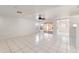 Bright living room with white tile flooring, a ceiling fan, and sliding glass door to patio at 8884 E Arizona Park Pl, Scottsdale, AZ 85260