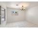 Bright living room featuring tile floors, white walls, updated lighting, and a large window at 8884 E Arizona Park Pl, Scottsdale, AZ 85260