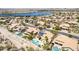 Aerial view of desert homes near a lake, complemented with solar panels and private backyard pools at 10794 S Coolwater Dr, Goodyear, AZ 85338