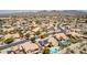 Expansive aerial view of desert homes featuring solar panels, swimming pools, and mountain views at 10794 S Coolwater Dr, Goodyear, AZ 85338