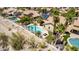 Aerial view of a backyard with a pool, lounge chairs, palm trees, and energy-saving solar panels at 10794 S Coolwater Dr, Goodyear, AZ 85338