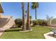 Lush backyard featuring artificial grass, palm trees, and a low-maintenance desert landscape at 10794 S Coolwater Dr, Goodyear, AZ 85338