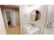 Bright bathroom features a marble vanity with a round mirror and a doorway leading into a bedroom at 10794 S Coolwater Dr, Goodyear, AZ 85338