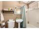 Bathroom featuring a pedestal sink, toilet, and tub with a blue and white patterned shower curtain at 10794 S Coolwater Dr, Goodyear, AZ 85338