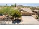 Inviting home with a three-car garage, tile roof, mature landscaping, and a spacious driveway at 10794 S Coolwater Dr, Goodyear, AZ 85338