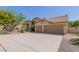 Attractive single-story home featuring a two-car garage, desert landscaping, and a tile roof at 10794 S Coolwater Dr, Goodyear, AZ 85338