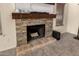 Close-up of a stone fireplace with a wooden mantle and hearth, adding warmth and style to the room at 10794 S Coolwater Dr, Goodyear, AZ 85338