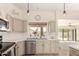 Bright kitchen showcases stainless steel appliances, light cabinetry, and a scenic view from the window at 10794 S Coolwater Dr, Goodyear, AZ 85338