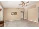 Neutral living room featuring plush carpeting, tile entry, and modern ceiling fan, with a seamless open floor plan at 10794 S Coolwater Dr, Goodyear, AZ 85338