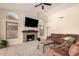 Comfortable living room with a stone fireplace, shiplap accent, and ceiling fan for added ambiance at 10794 S Coolwater Dr, Goodyear, AZ 85338