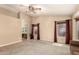 Bright living room features neutral tones, carpet flooring, and natural light from large windows with brick-red curtains at 10794 S Coolwater Dr, Goodyear, AZ 85338