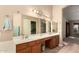 Double sink vanity in the main bath featuring warm wood cabinets and a large framed mirror at 10794 S Coolwater Dr, Goodyear, AZ 85338