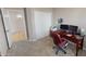 Bright office space with large closet, dark wood desk, and red rolling chair at 10794 S Coolwater Dr, Goodyear, AZ 85338