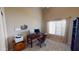 Spacious office includes a dark wood desk and rolling chair, shelving and large window at 10794 S Coolwater Dr, Goodyear, AZ 85338