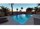 Backyard pool with palm trees, waterfall feature, and basketball hoop for outdoor entertainment at 10794 S Coolwater Dr, Goodyear, AZ 85338