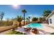 Backyard pool with palm trees and chairs create a relaxing outdoor oasis for entertaining at 10794 S Coolwater Dr, Goodyear, AZ 85338