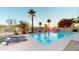 Backyard pool with palm trees, waterfall feature, and lounge chairs for outdoor entertainment at 10794 S Coolwater Dr, Goodyear, AZ 85338