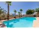 Resort style pool with mature palm trees and waterfall feature at 10794 S Coolwater Dr, Goodyear, AZ 85338