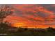 Panoramic sunset view over a community of homes, featuring vibrant colors and lush greenery at 10794 S Coolwater Dr, Goodyear, AZ 85338
