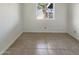 Clean, well-lit bedroom features tile flooring and a window overlooking the backyard at 1105 W Anderson Dr, Phoenix, AZ 85023