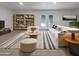 Bright living room featuring stylish decor, a bookshelf, and sliding glass doors to the backyard at 1105 W Anderson Dr, Phoenix, AZ 85023