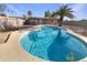 Backyard with a sparkling swimming pool, surrounded by palm trees and secure fencing at 1105 W Anderson Dr, Phoenix, AZ 85023