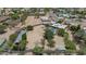 An aerial view shows a large property featuring a pool, a putting green, and a covered parking area at 12682 N 80Th Pl, Scottsdale, AZ 85260