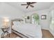 Bright bedroom with a bed, ceiling fan, a unique arched window, and natural light at 12682 N 80Th Pl, Scottsdale, AZ 85260