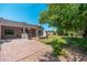 Spacious backyard featuring a brick patio, outdoor fireplace, and lush green lawn at 13034 W Krall Ct, Glendale, AZ 85307