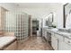 Spacious bathroom featuring unique glass block shower, large tub, and double vanity at 13034 W Krall Ct, Glendale, AZ 85307