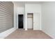 Neutral bedroom with carpet features a wall closet with slider door and a black entry door at 13034 W Krall Ct, Glendale, AZ 85307