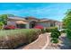 Beautiful exterior elevation with colorful shrubbery, an umbrella-covered patio, and solar panels on the roof at 13034 W Krall Ct, Glendale, AZ 85307