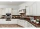 Well-lit kitchen with stainless steel appliances, granite counters, and white cabinets at 13034 W Krall Ct, Glendale, AZ 85307