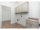 Well-lit laundry room features storage cabinets, a sink with granite counters, and a utility closet at 13034 W Krall Ct, Glendale, AZ 85307