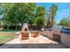 Outdoor patio with stone fireplace, built-in grill, and wood chairs at 13034 W Krall Ct, Glendale, AZ 85307