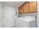 Bright laundry room features a full-size white washer and dryer, with wood cabinets and storage space at 132 W Wood Dr, Phoenix, AZ 85029