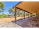 Covered patio features stone flooring, dark wood supports, and views of the desert landscape, blending indoor and outdoor living at 132 W Wood Dr, Phoenix, AZ 85029
