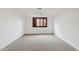 Bright bedroom features neutral carpet, fresh white walls, and a window with wood-stained shutters at 1417 W Los Arboles Pl, Chandler, AZ 85224