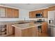 Bright kitchen with wood cabinets, granite counters, stainless appliances, and center island at 1417 W Los Arboles Pl, Chandler, AZ 85224