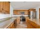 Bright kitchen with granite counters, stainless appliances, and wood cabinets at 1417 W Los Arboles Pl, Chandler, AZ 85224