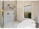 Modern bathroom with a luxurious walk-in shower, soaker tub, and large window at 14518 N 99Th St, Scottsdale, AZ 85260
