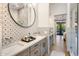 Bright bathroom featuring double sinks, patterned tile, and an open doorway to the pool at 14518 N 99Th St, Scottsdale, AZ 85260