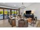 Cozy living room with plush seating, a stylish chandelier, and a view of the pool area at 14518 N 99Th St, Scottsdale, AZ 85260