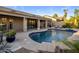 A private pool with travertine tilework, concrete patio, lounge chairs, and desert landscaping offers relaxation at 14518 N 99Th St, Scottsdale, AZ 85260