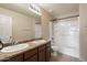 Bathroom featuring a double vanity, tile floor, and shower-tub combo at 15844 W Lisbon Ln, Surprise, AZ 85379